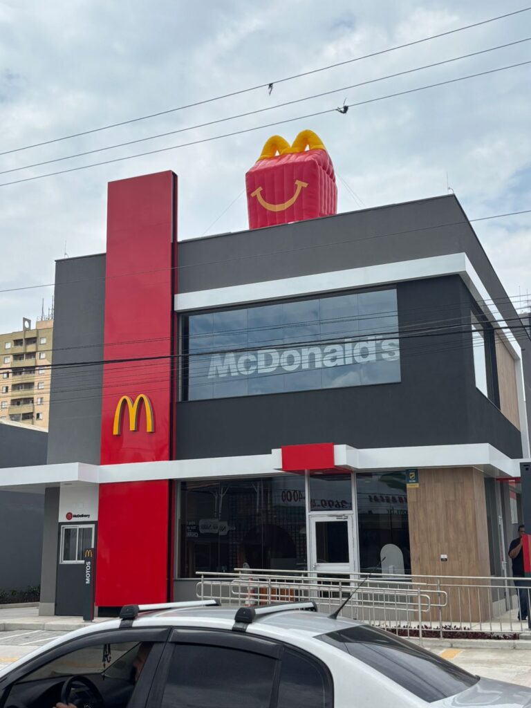 Réplica inflável da caixa do McLanche Feliz vista da rua, no telhado da loja